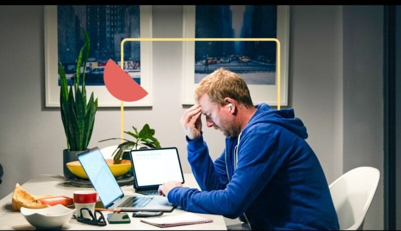 personal loan rates 2026: American man sitting at home office stressed comparing personal loan offers on laptop with calculator and papers, financial planning concept